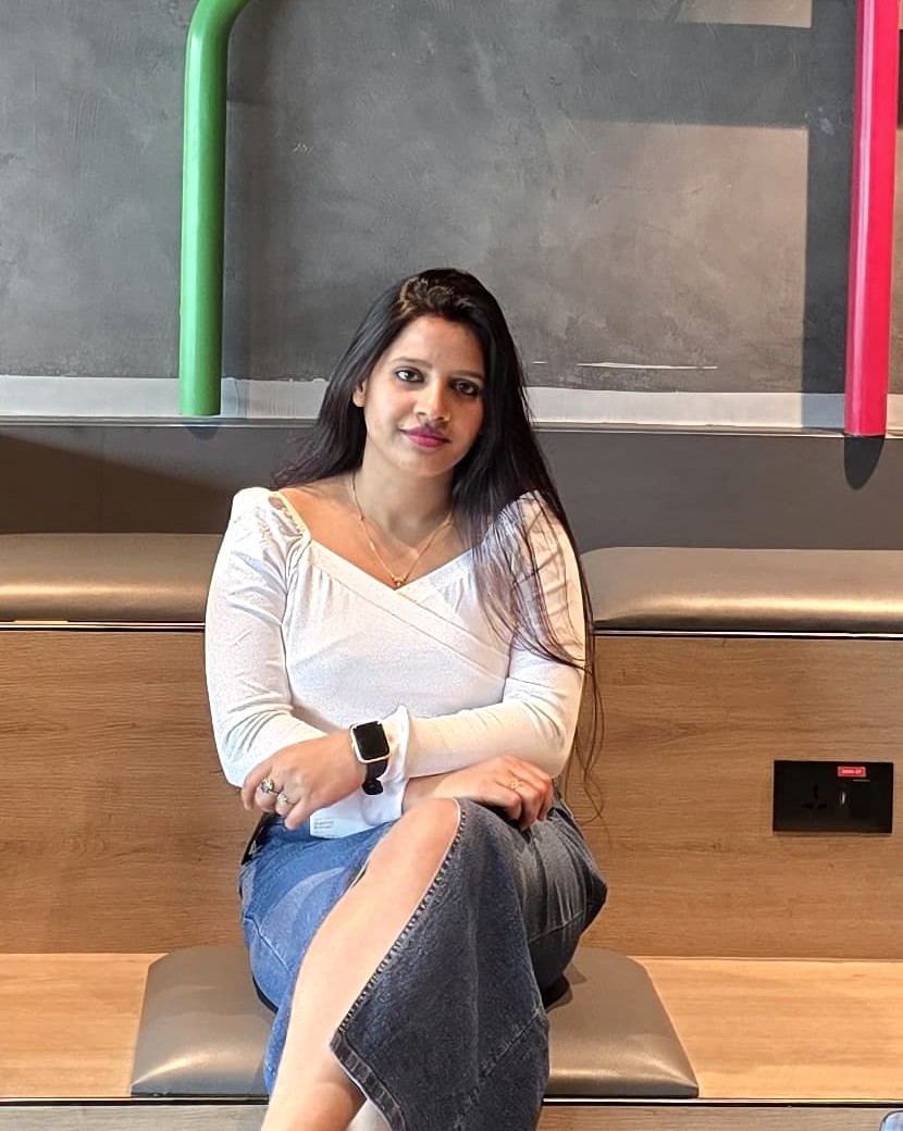 Portrait of Rashmi Kumari, seated in a modern office workspace